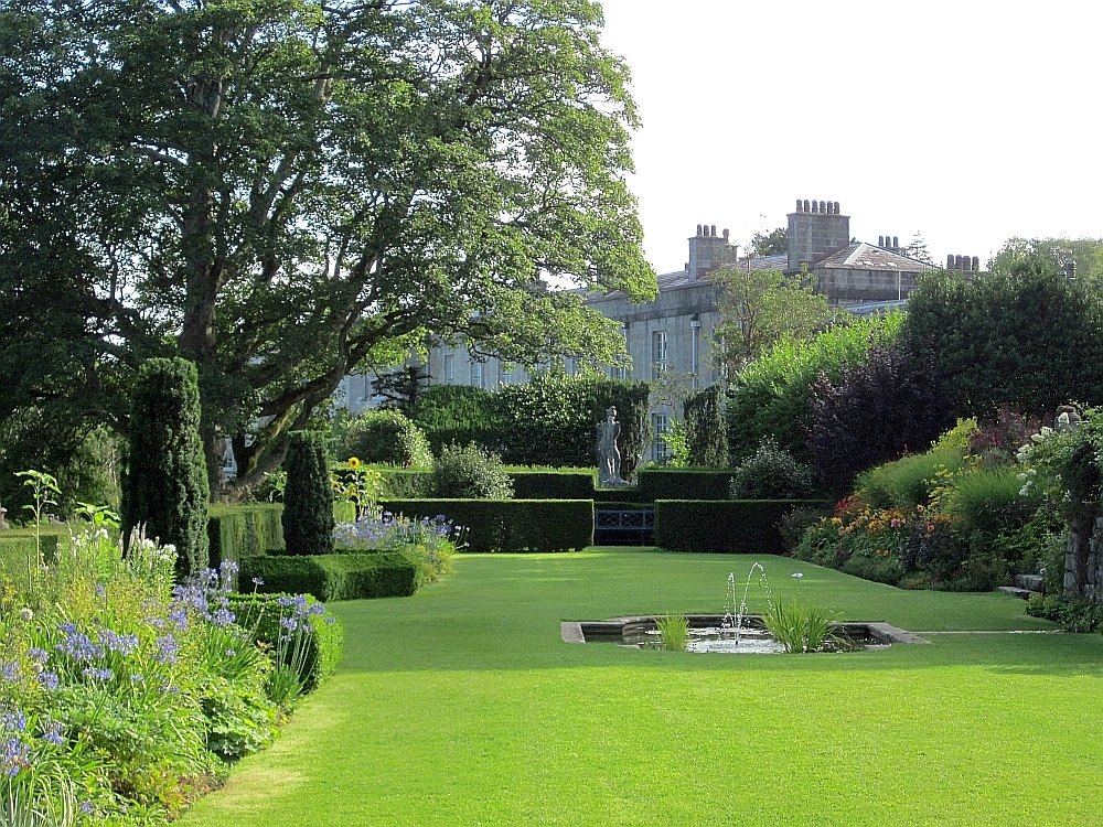 A green lawn edged with flower borders in a large British garden